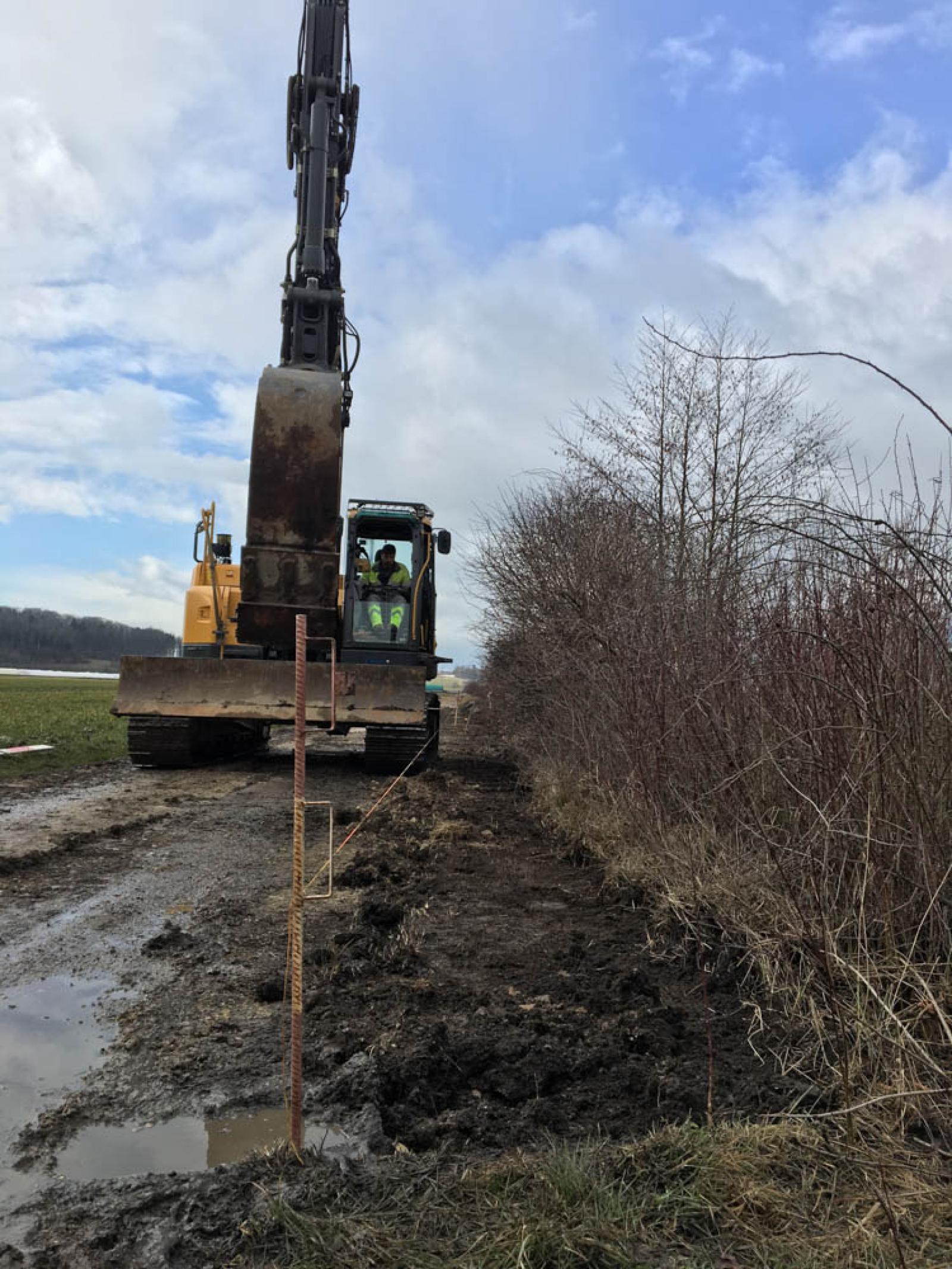 Travaux de creusement d'une tranchée entre le chemin agricole et le talus